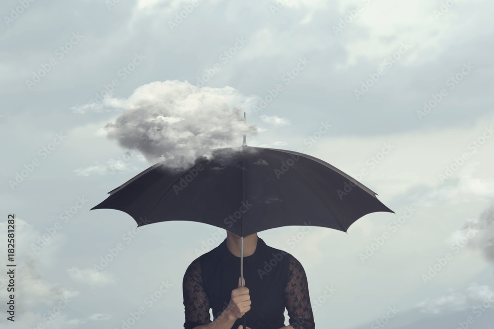surreal moment of a woman hiding under the umbrella from a small cloud that chases her