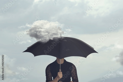 Φωτογραφία surreal moment of a woman hiding under the umbrella from a small cloud that chas