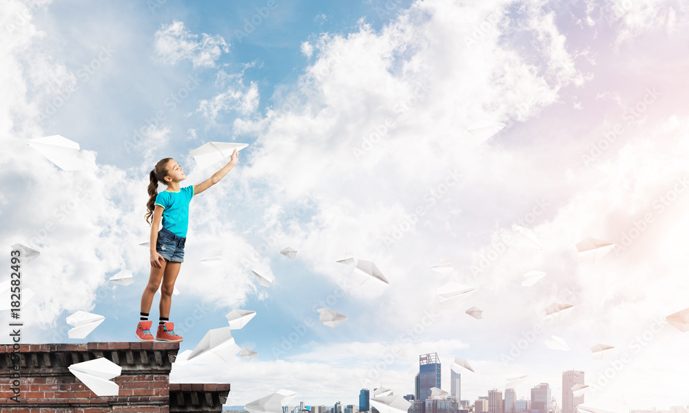 Concept of careless happy childhood with girl dreaming to become pilot Concept of careless happy childhood with girl dreaming to become pilot