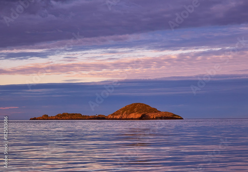 Beautiful sunset sky and reflection on calm sea with the island