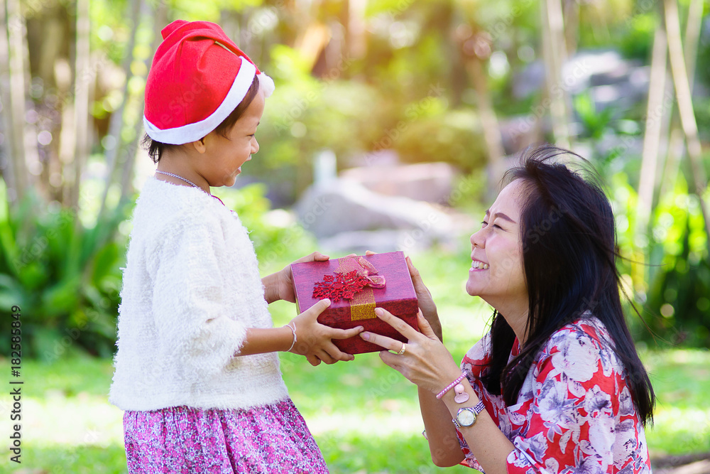 Obraz premium Mother and daughter giving and receiving gift box with happy and surprise in xmas day.