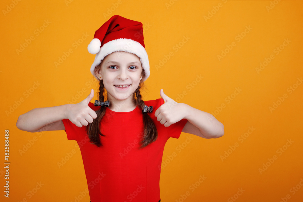 Portrait of Young Santa Claus girl in red clothes with on yellow background Portrait of Young Santa Claus girl in red clothes with on yellow background