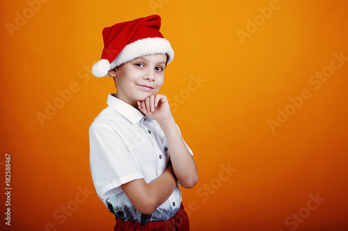 Cute little boy in a cap Santa Claus on a yellow background. Copyspace © olgasparrow