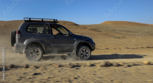 A jeep drives through the desert © yarin