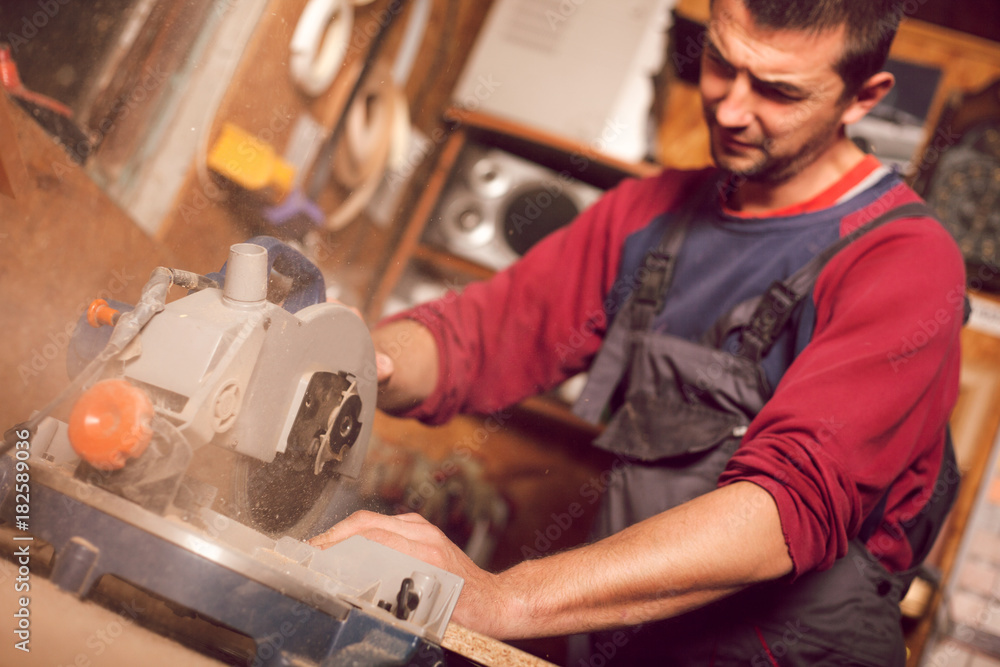 Carpenter using circular saw for cutting wooden boards Carpenter using circular saw for cutting wooden boards