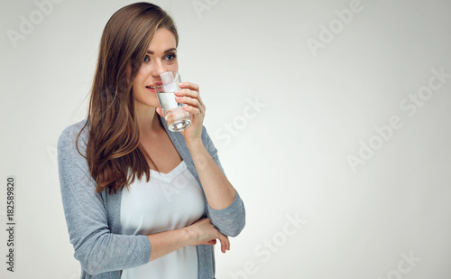 Portrait of smiling woman with long hair holding water glass.