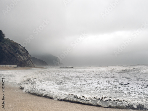 Stürmische Meerlandschaft Küste an einem stürmischen Tag mit Felsen Bergen und Meer im Hintergrund