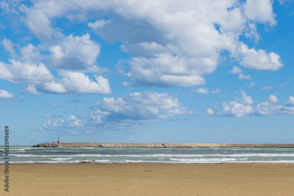 View of a winter beach with sky and white clouds View of a winter beach with sky and white clouds