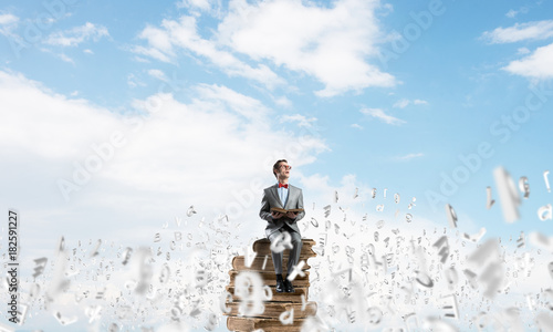 Young businessman or student studying the science and symbols fly around © adam121