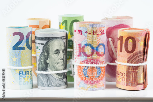 Currencies and money exchange trading concepts. The rolls of various currencies US Dollar, Euro and Chinese yuan banknotes isolated on white background.