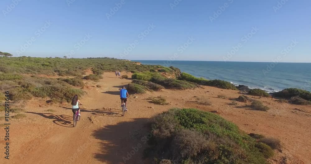 Aerial view of young couple riding in bike near to the beach Aerial view of young couple riding in bike near to the beach