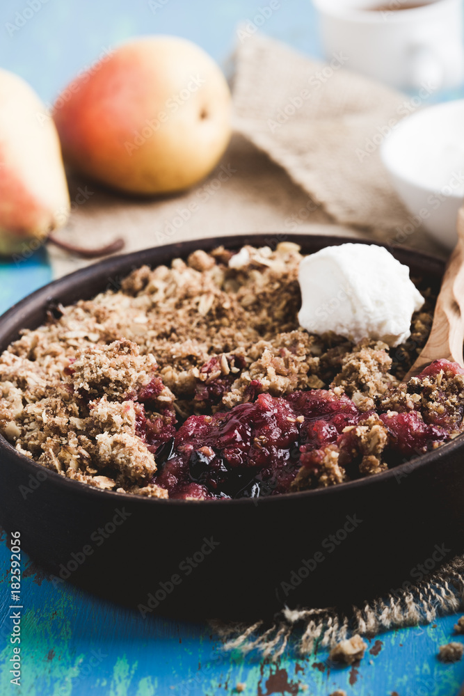 Pear and berry crumbles served with cream Pear and berry crumbles served with cream