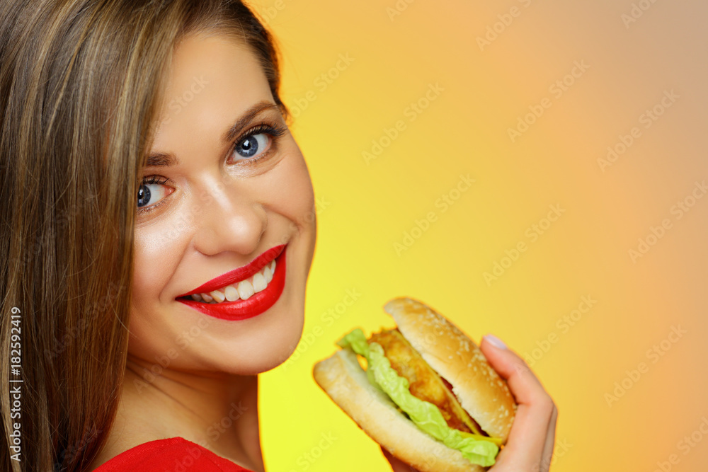 Close up face portrait of woman eating burger.