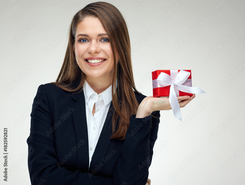 Smiling businesswoman wearing black business suit holding small red gift box Smiling businesswoman wearing black business suit holding small red gift box