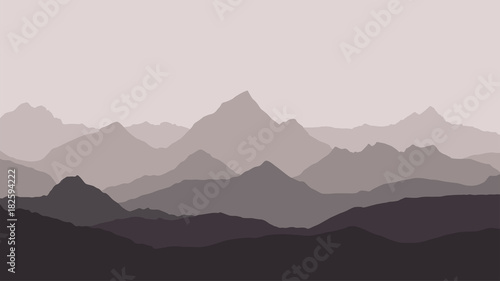 panoramic view of the mountain landscape with fog in the valley below with the alpenglow grey sky and haze background
