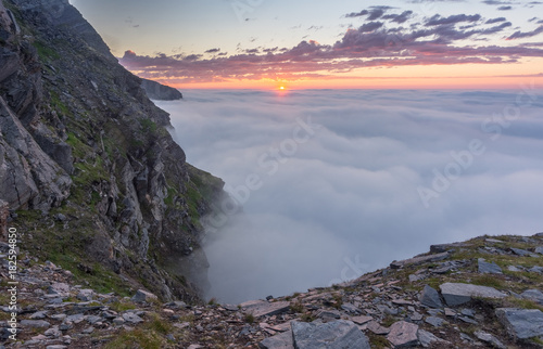 Sunset in the fog on the rocks of Soroya Island, Norway