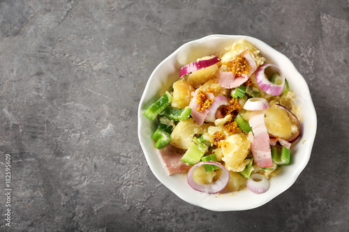 Bowl with delicious potato salad on table