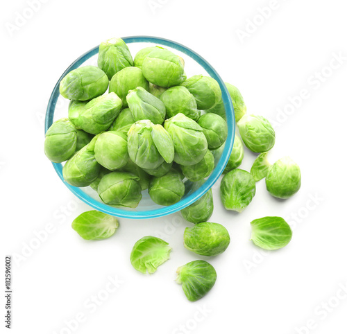 Fresh Brussels sprouts in glass bowl on white background