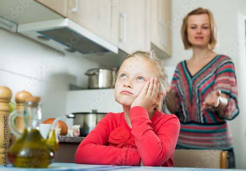 Frustrated mother scolding little kid photo