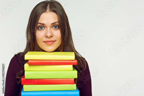 Close up portrait of student girl with books pile.
