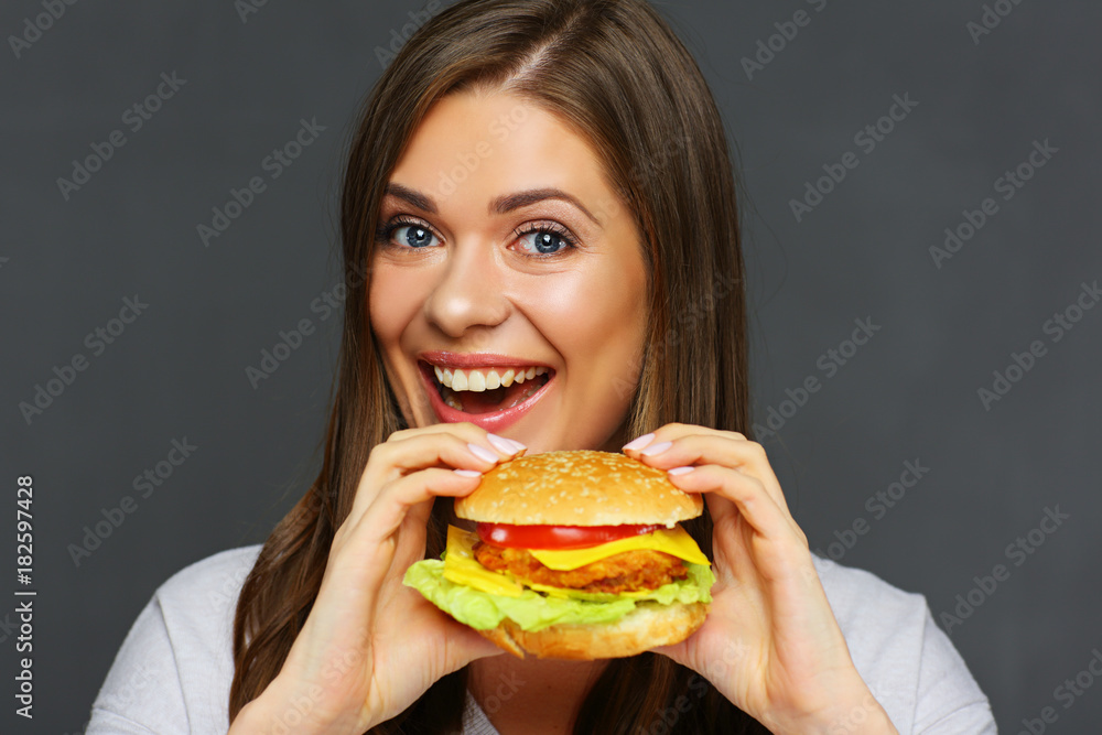 Smiling girl holding big burger. Smiling girl holding big burger.