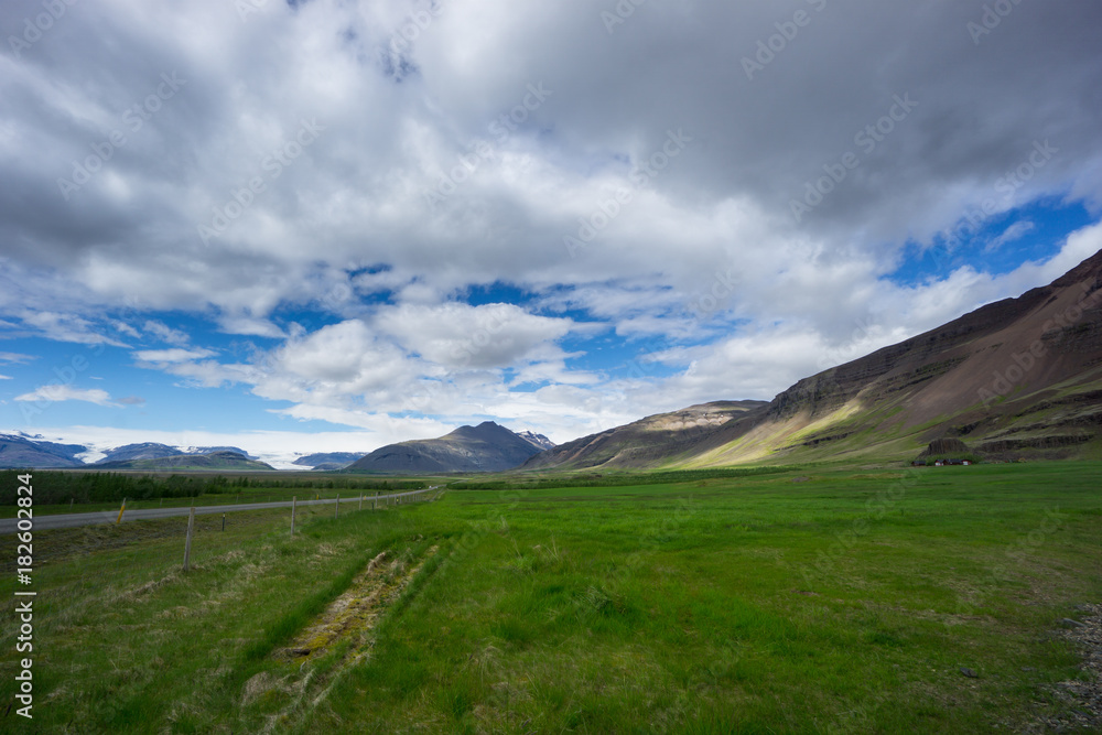 Iceland - Green flat with street between volcanoes and glaciers