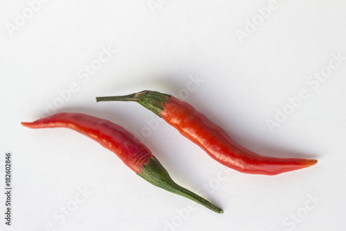 Two red chili peppers on white background. Top view. Horizontally