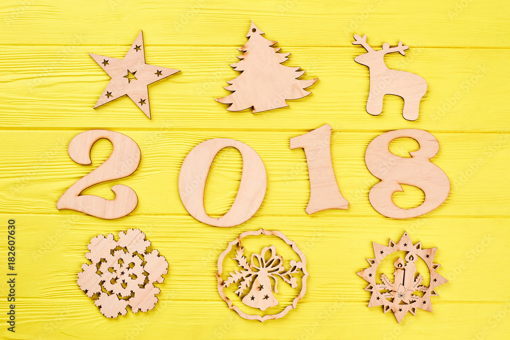 Number 2018 and wooden New Year figures. Christmas background with decorations. Wooden handmade carved figures of star, deer, spruce, candles on colored background. Number 2018 and wooden New Year figures. Christmas background with decorations. Wooden handmade carved figures of star, deer, spruce, candles on colored background.