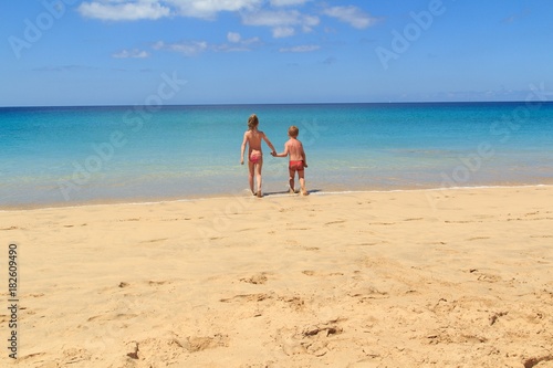 The boy and the girl on the beach go to sea together, Fuerteventura- Canary Islands