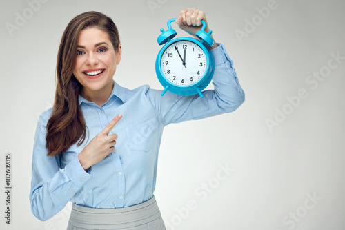 Businesswoman holding alarm clock pointing finger photo