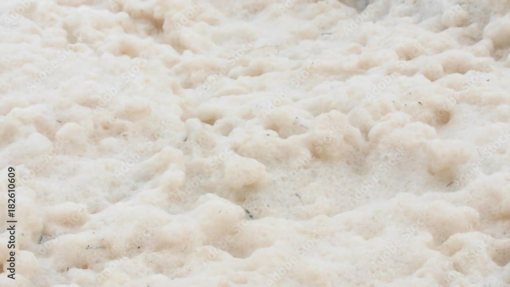 Foam on rocky ocean shoreline in rough water from storm Foam on rocky ocean shoreline in rough water from storm