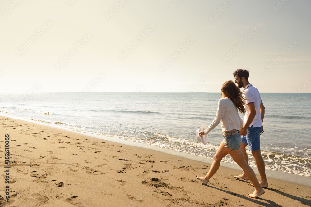 Young happy couple on seashore. Male has beard.