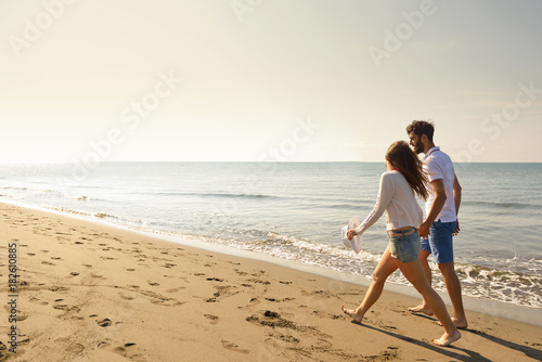 Young happy couple on seashore. Male has beard.