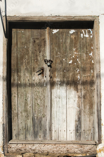 Old weathered vintage wooden rural grunge door of abandoned country house closeup