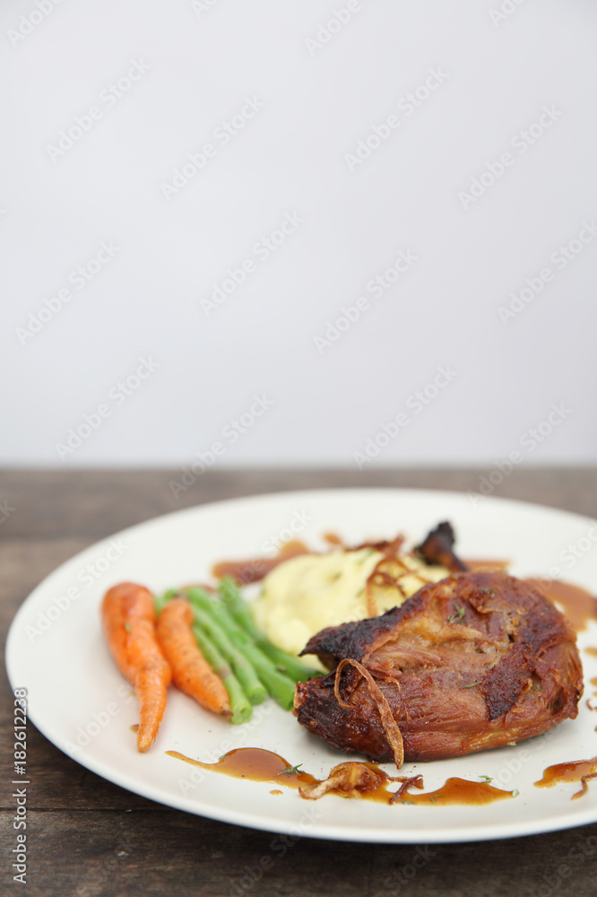 duck confit , Grilled duck steak with carrot and asparagus on wood background