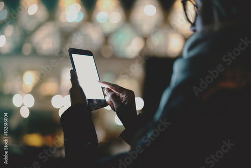 Cropped image of woman's hands holding mobile phone with blank copy space screen for your text message or advertising content, female using route apps on smartphone while relaxing outdoors.