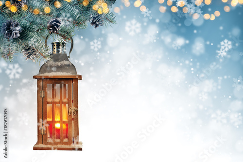 Christmas background with spruce branches and wooden lantern.