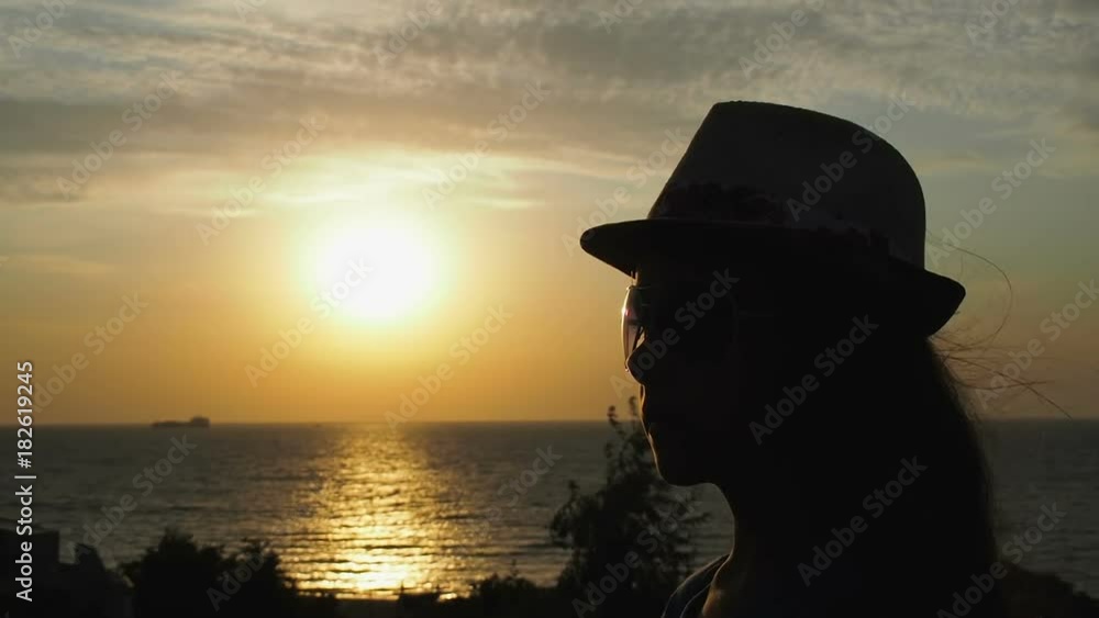 Silhouette of little girl in hat and glasses on the background of the sea. Silhouette of little girl in hat and glasses on the background of the sea.