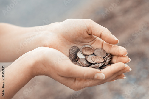 Handful of coins in palm female hands. Concept of saving and passive income