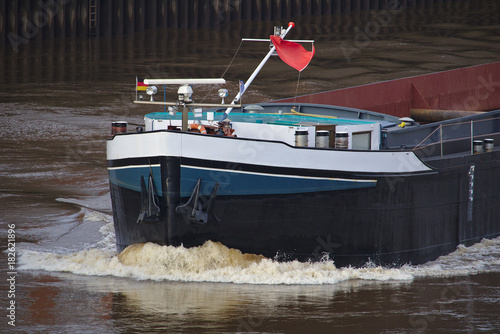 Bow of inland vessel running at high speed with white foaming bow wave