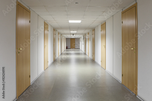 Fotografija Empty office corridor with many doors of light wood.