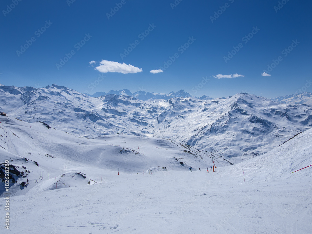 ski slopes full of snow surrounded by steep peaks