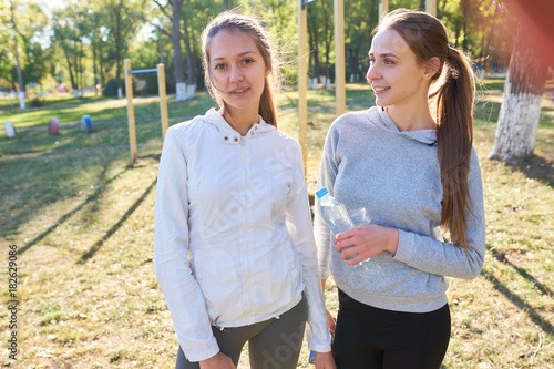 Two sports girls stand and rest after exercise.