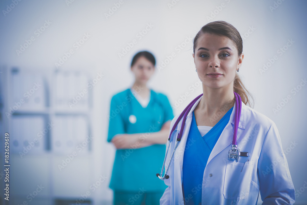 Attractive female doctor in front of medical group. Attractive female doctor in front of medical group.