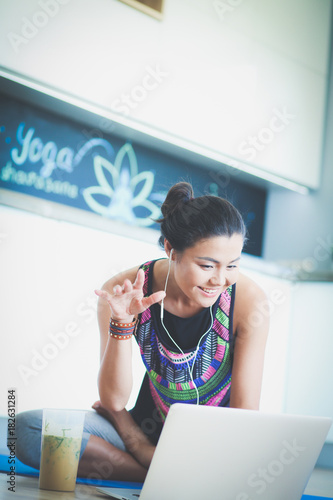 Sporty smiling woman using laptop in bright room. Woman. Lifestyle photo