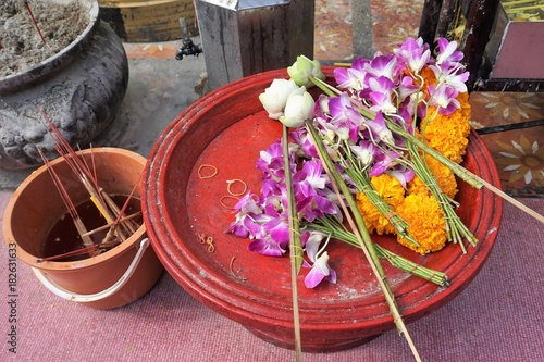 Buddhist requisites with flowers at temple in Thailand photo