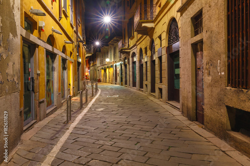 Typical Italian medieval street at night in the centre of the Old Town of Milan, Lombardia, Italy