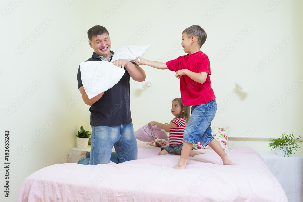 Family Concepts and Ideas. young Caucasian Family Having a Playful Funny Pillow Fight Indoors.
