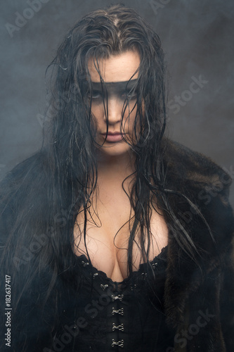 Cyberpunk female with wet hair in fog, painted eye mask