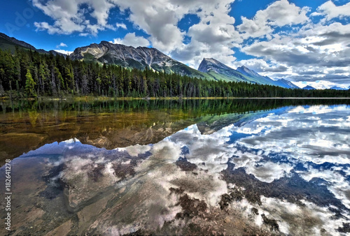 Honeymoon lake surronded by forest and mountains. Beautiful reflections in crystal clear water of lake. Jasper National Park. Alberta. Canada photo